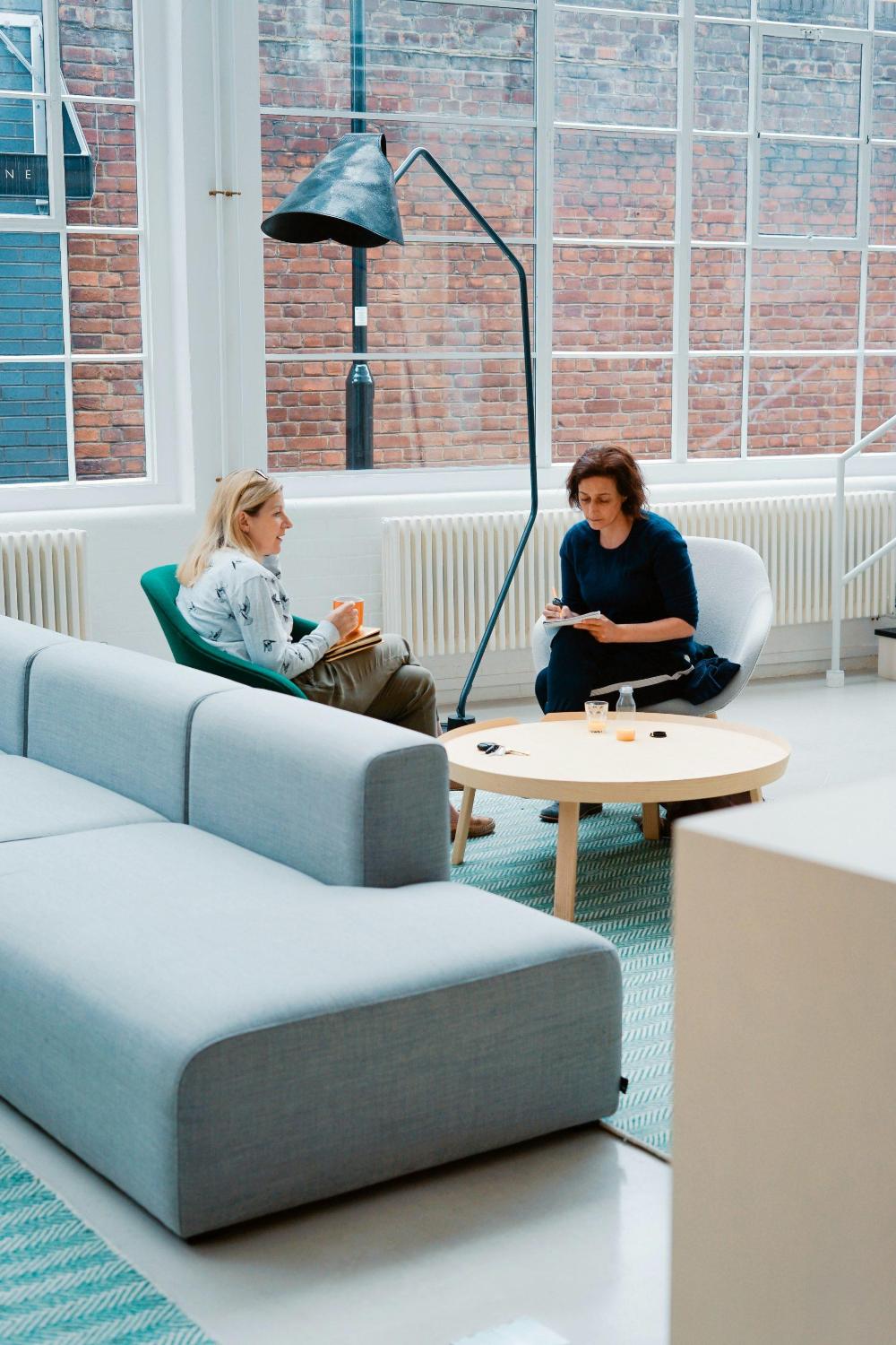 Two women having a conversation in office.