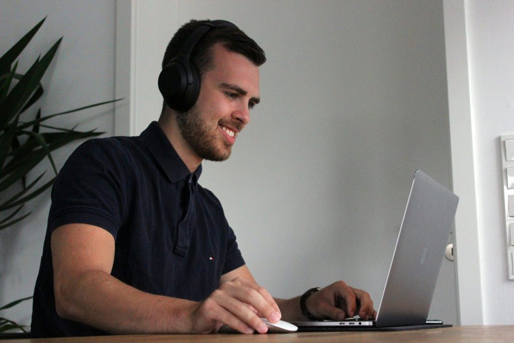 Man wearing headphones, working on laptop.