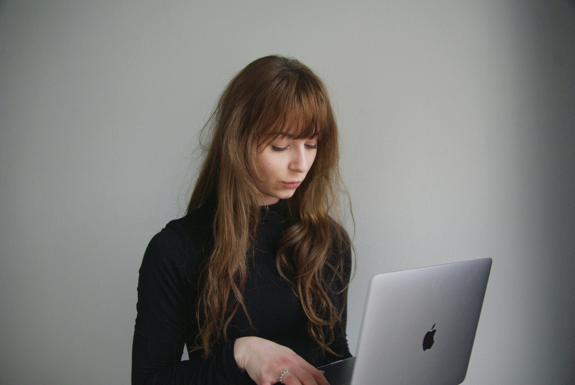 Woman working on a laptop, focused expression.