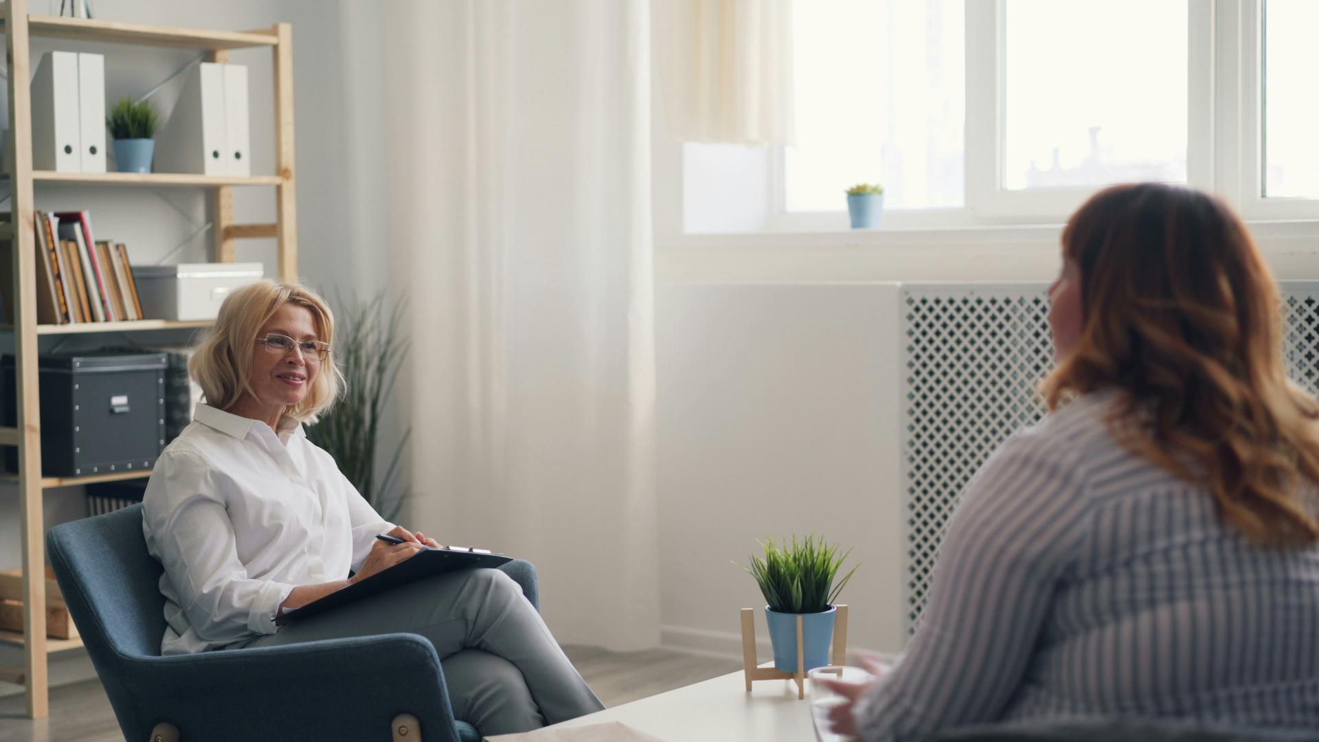 Therapist smiling while speaking with a client