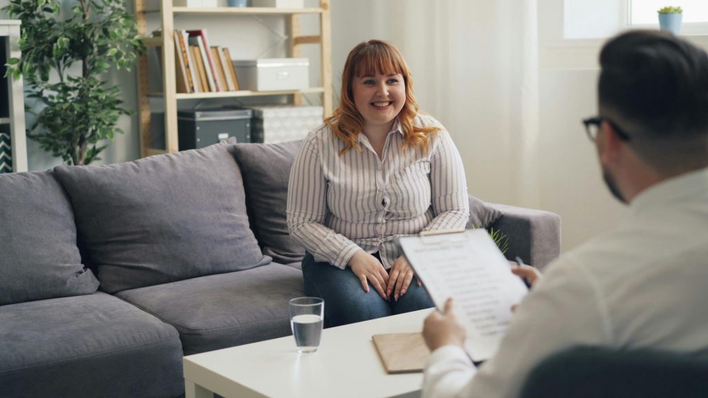Happy woman in therapy, engaging with counselor.